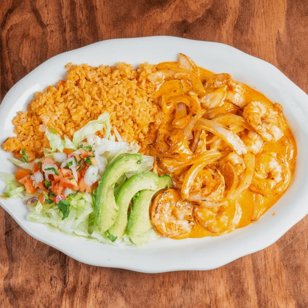 Shrimp in orange sauce with onions, rice, avocado slices, and pico de gallo on a white plate.