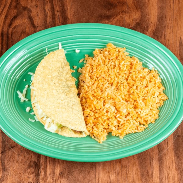 A crispy taco filled with lettuce and cheese, served with a side of orange rice on a green plate.