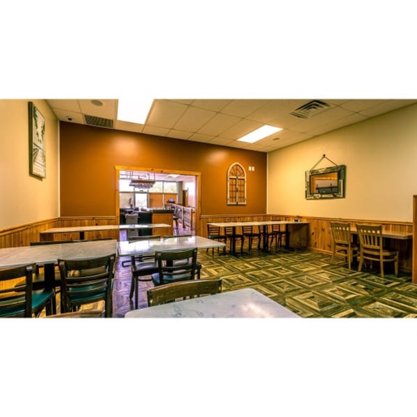 Mi Casa Mexican Restaurant dining room with tables, chairs, and a view into the kitchen.